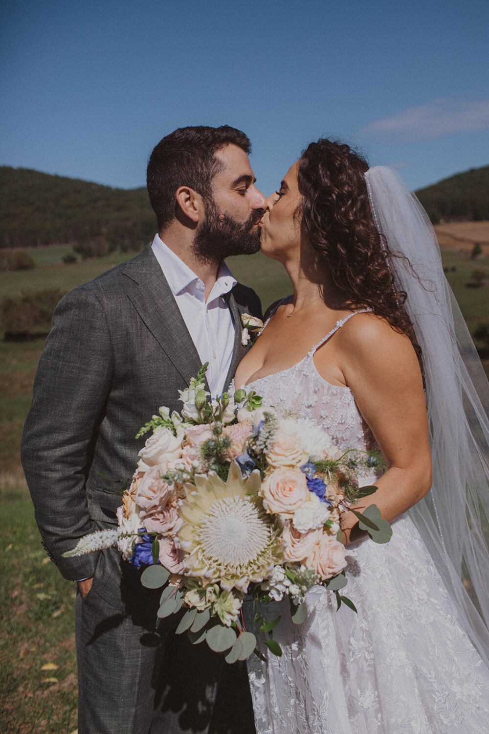 couple embraces in meadow