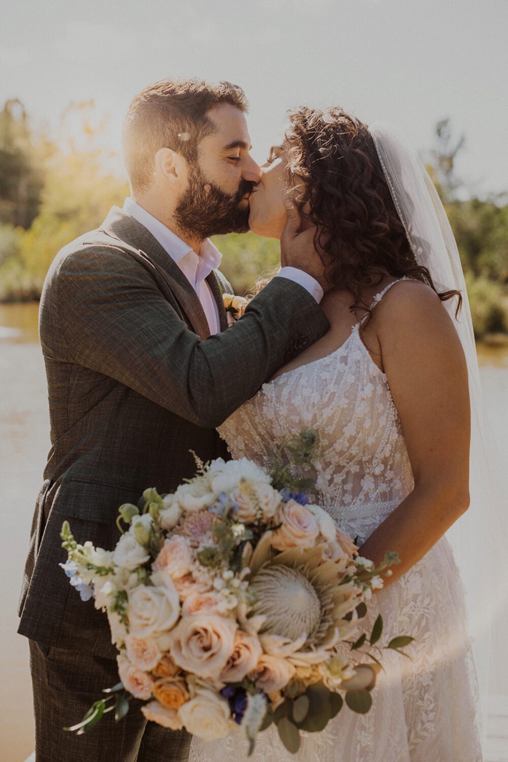 couple kisses at outdoor wedding