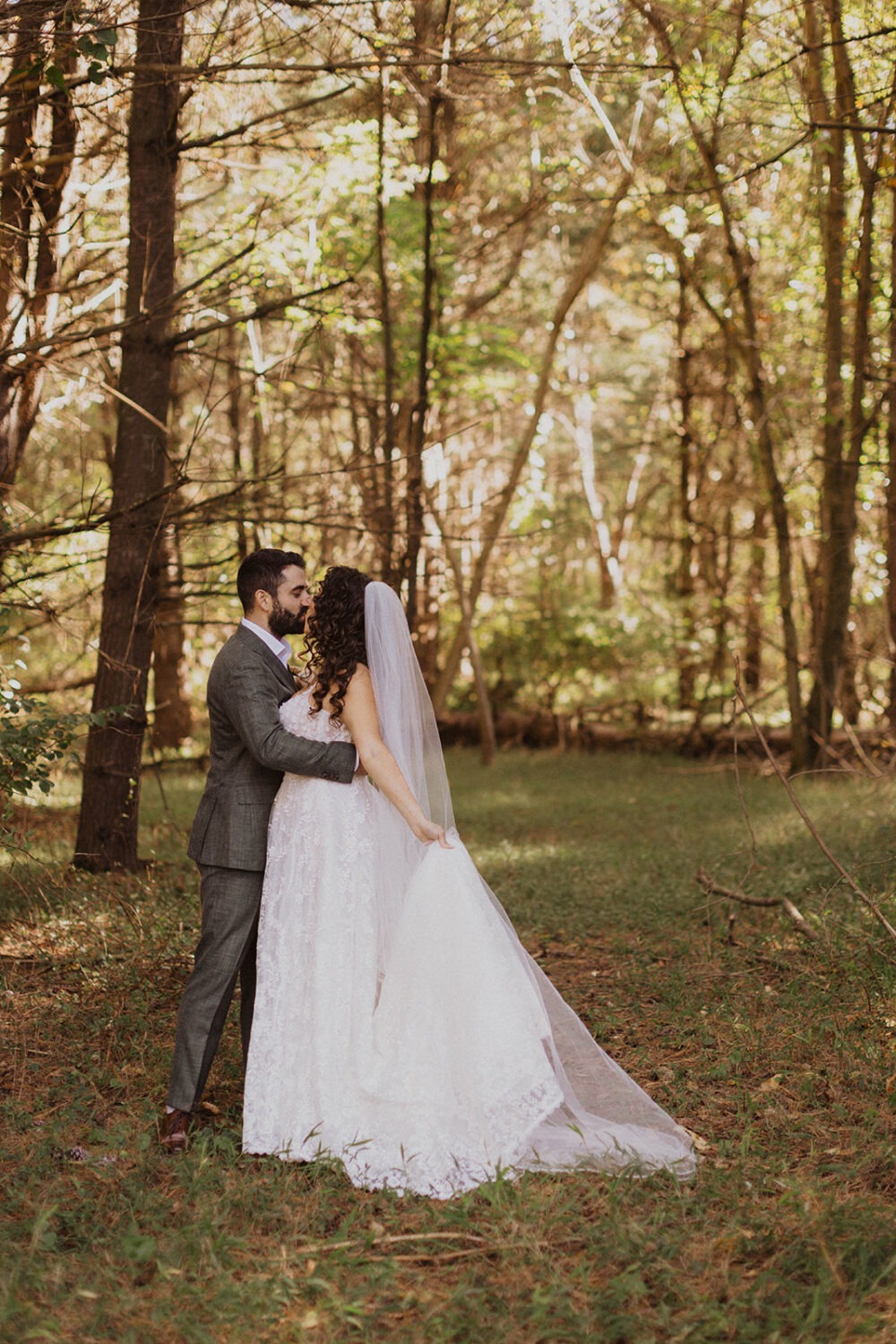 couple kisses at sunset forest wedding