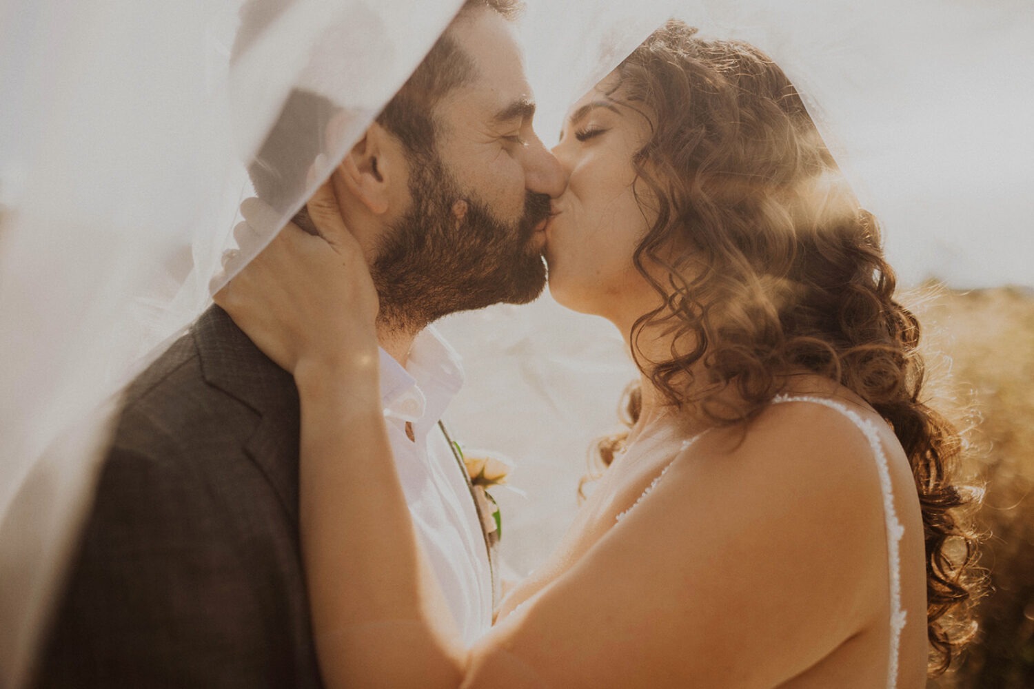 couple kisses at sunset wedding