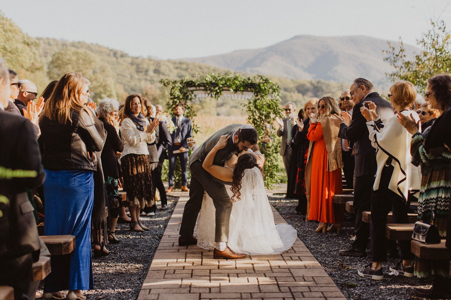 couple kisses in aisle during wedding ceremony