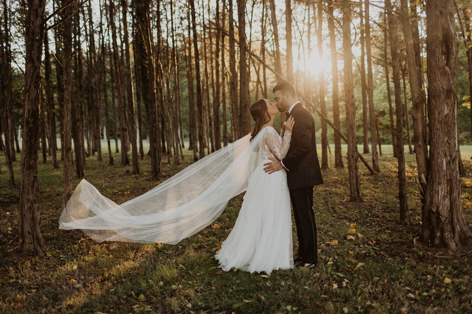 couple kisses during sunset forest wedding 