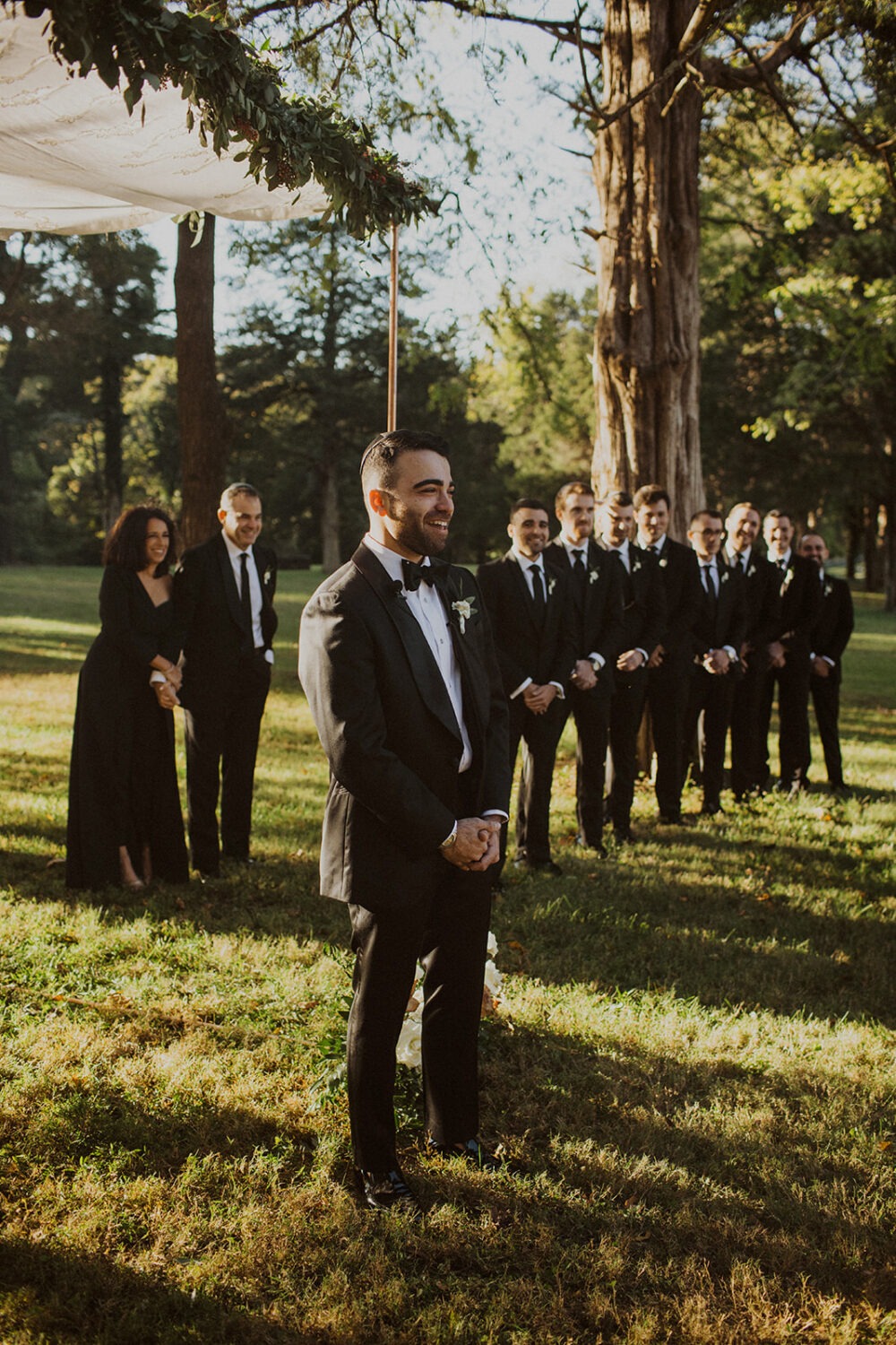 groom watches bride approach at sunset wedding 