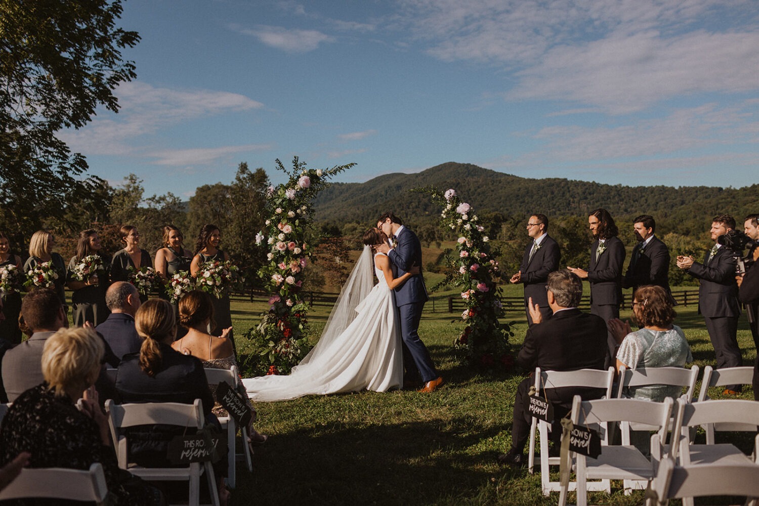 couple kisses at outdoor wedding ceremony