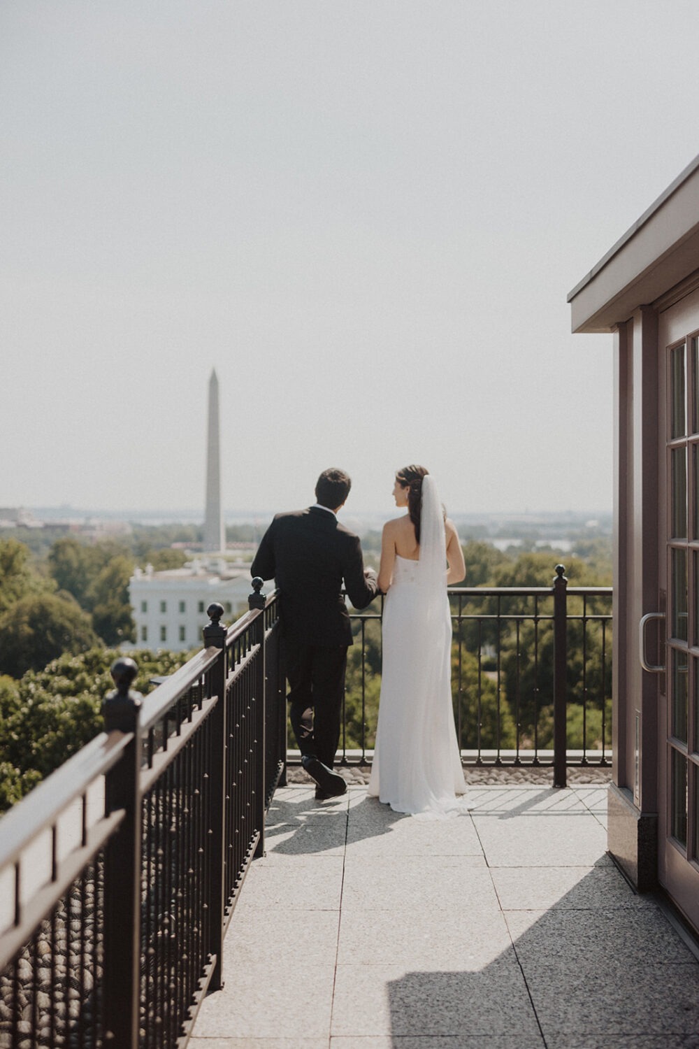 Bride and groom looking at Washington Monument.