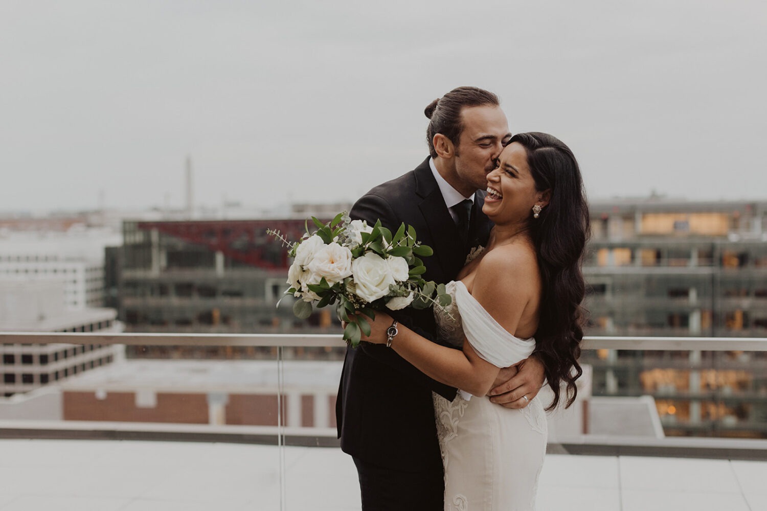 couple kisses at their DC rooftop wedding venue