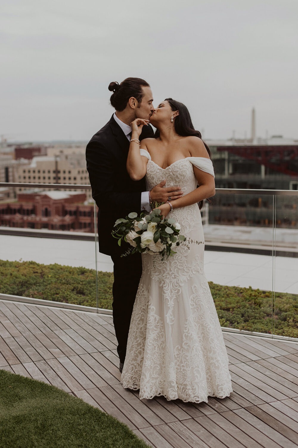 couple kisses at their DC rooftop wedding venue