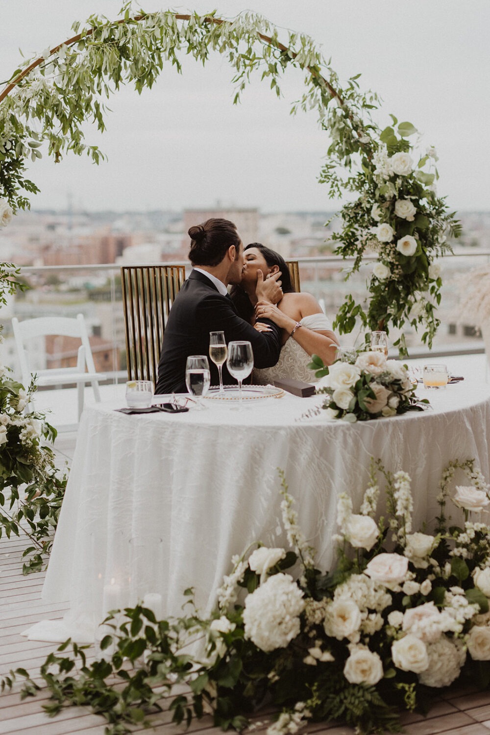 couple kisses at their DC rooftop wedding venue