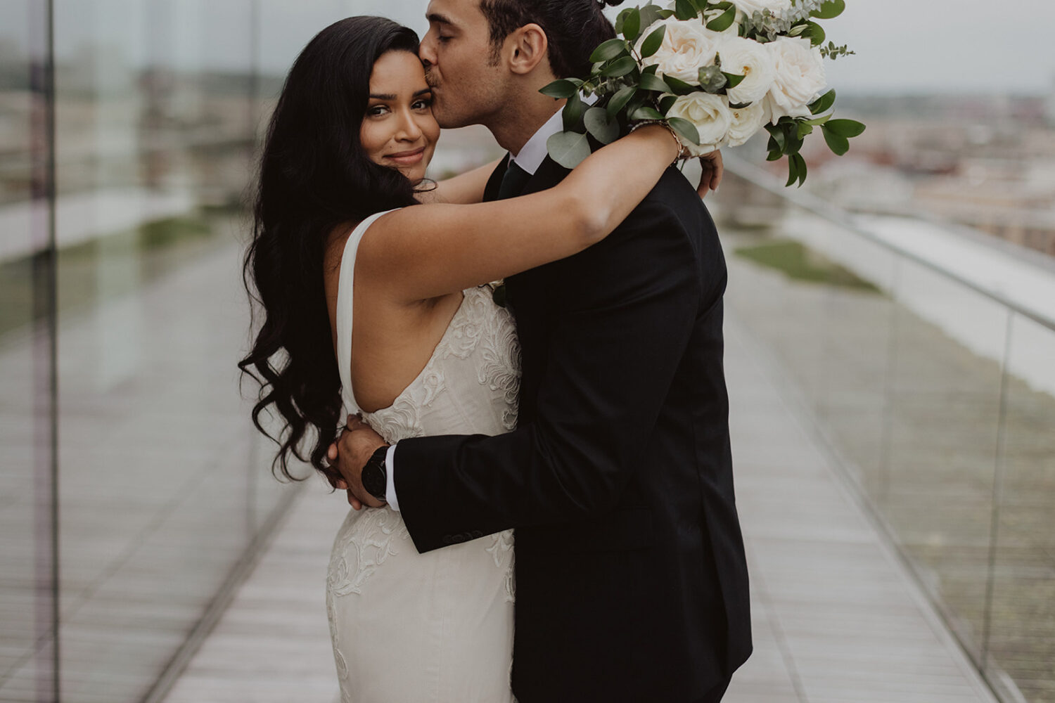 couple kisses at their DC rooftop wedding venue