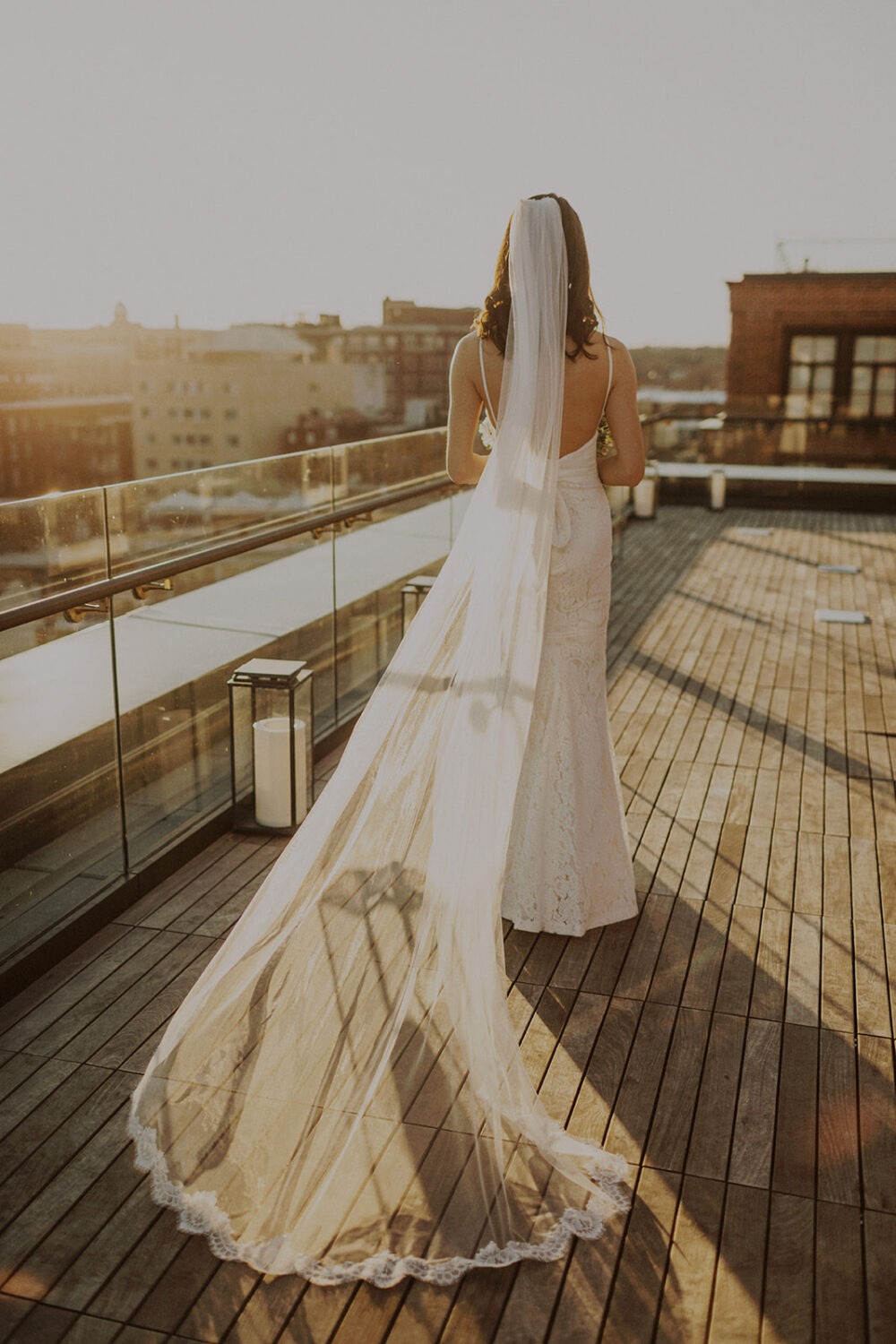 white long wedding veil in sunlight at sunset rooftop wedding