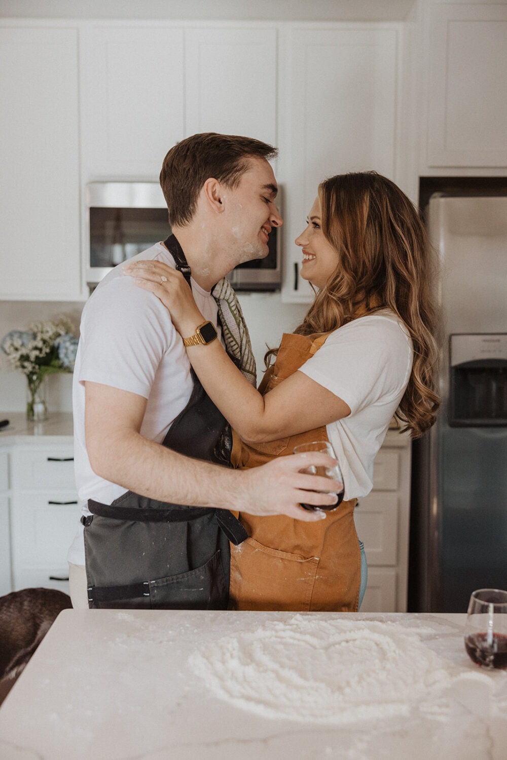 couple makes pizza together at home engagement session