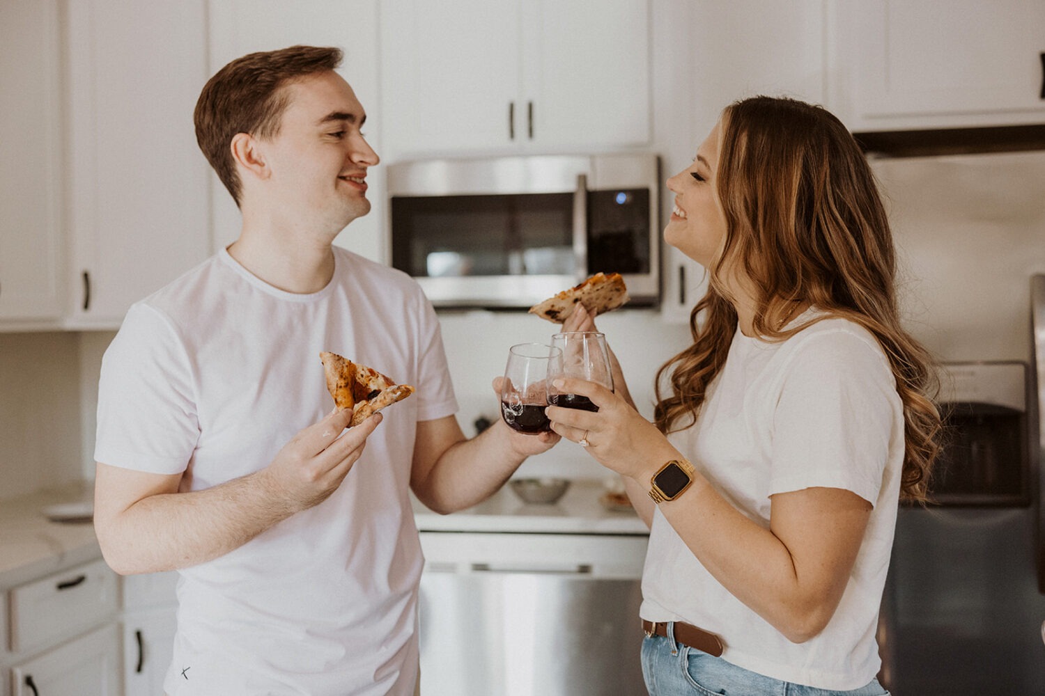 couple eats pizza together at home engagement session