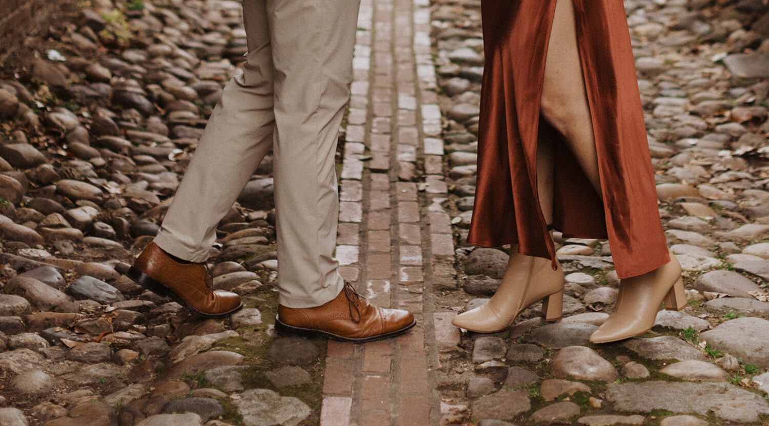 couple stands on cobblestone streets at winter engagement photoshoot 