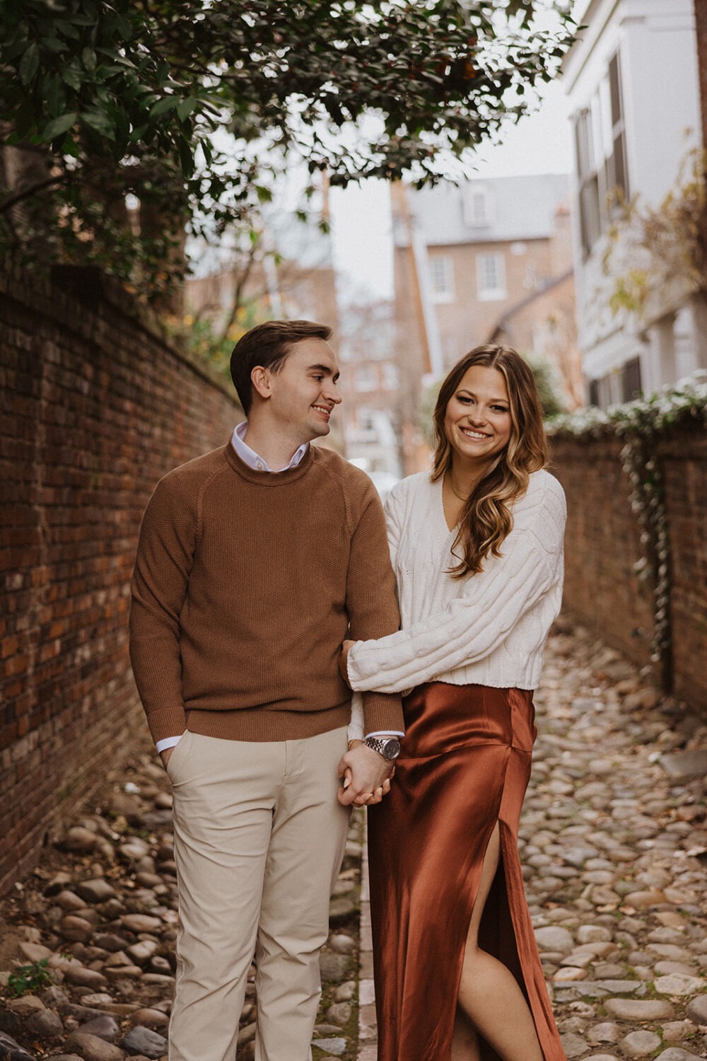 couple embraces on cobblestone streets at winter engagement photoshoot