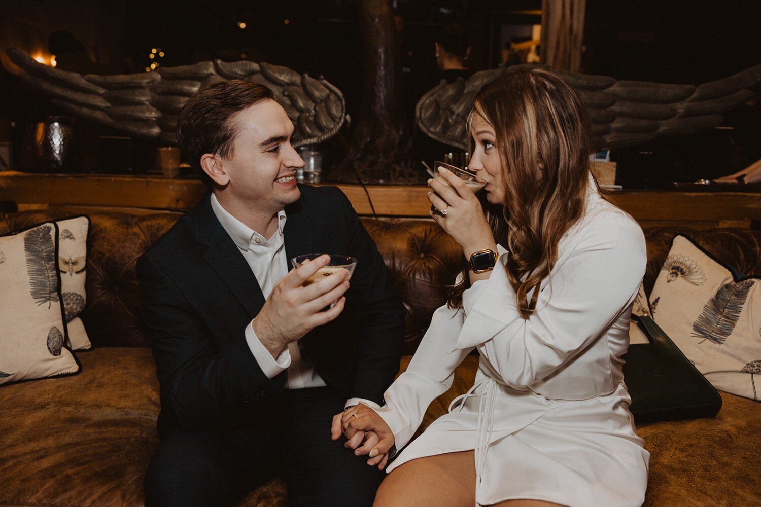 couple drinks cocktails at winter engagement photoshoot