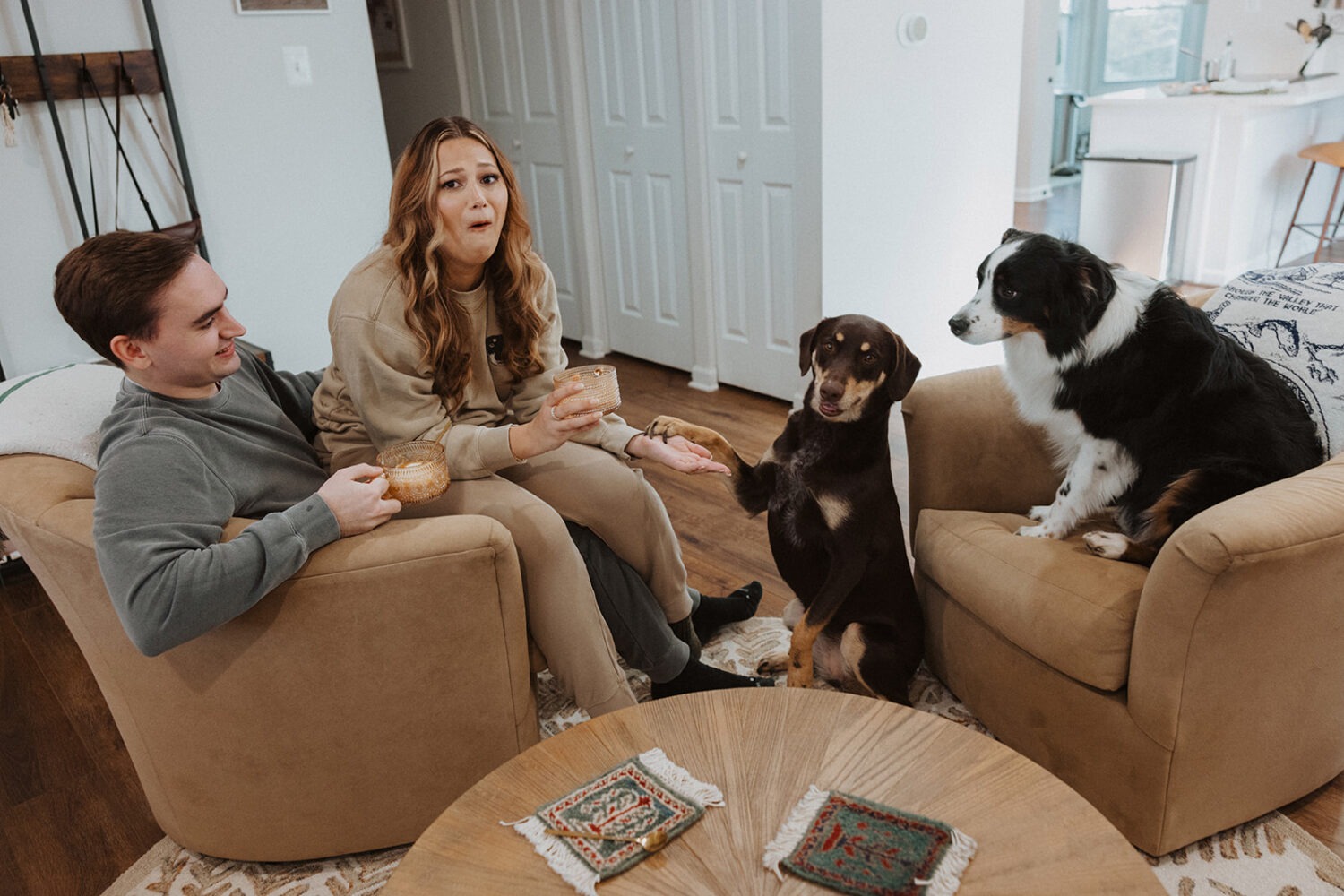 couple poses with dogs at home engagement session