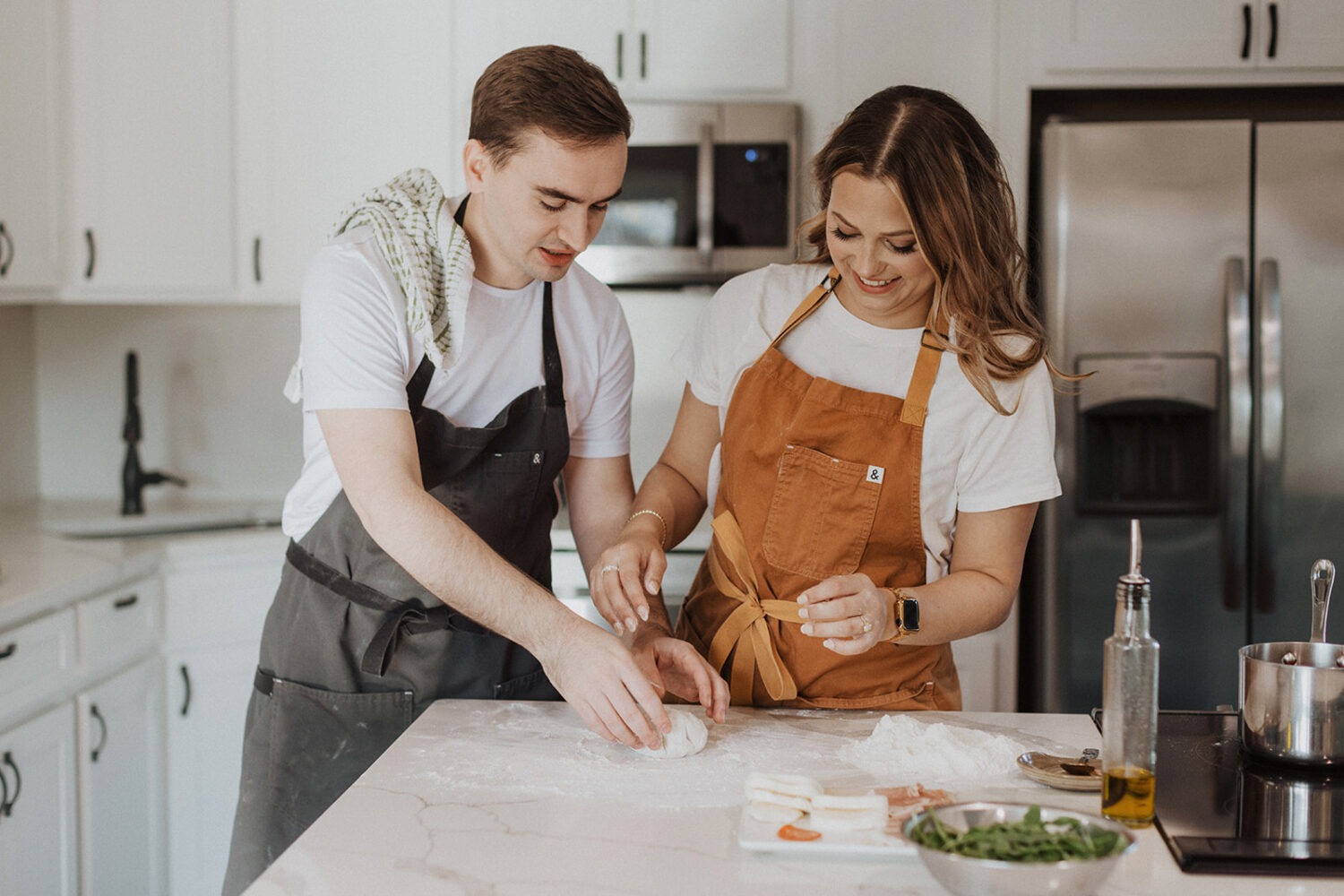 couple makes pizza together at home engagement session