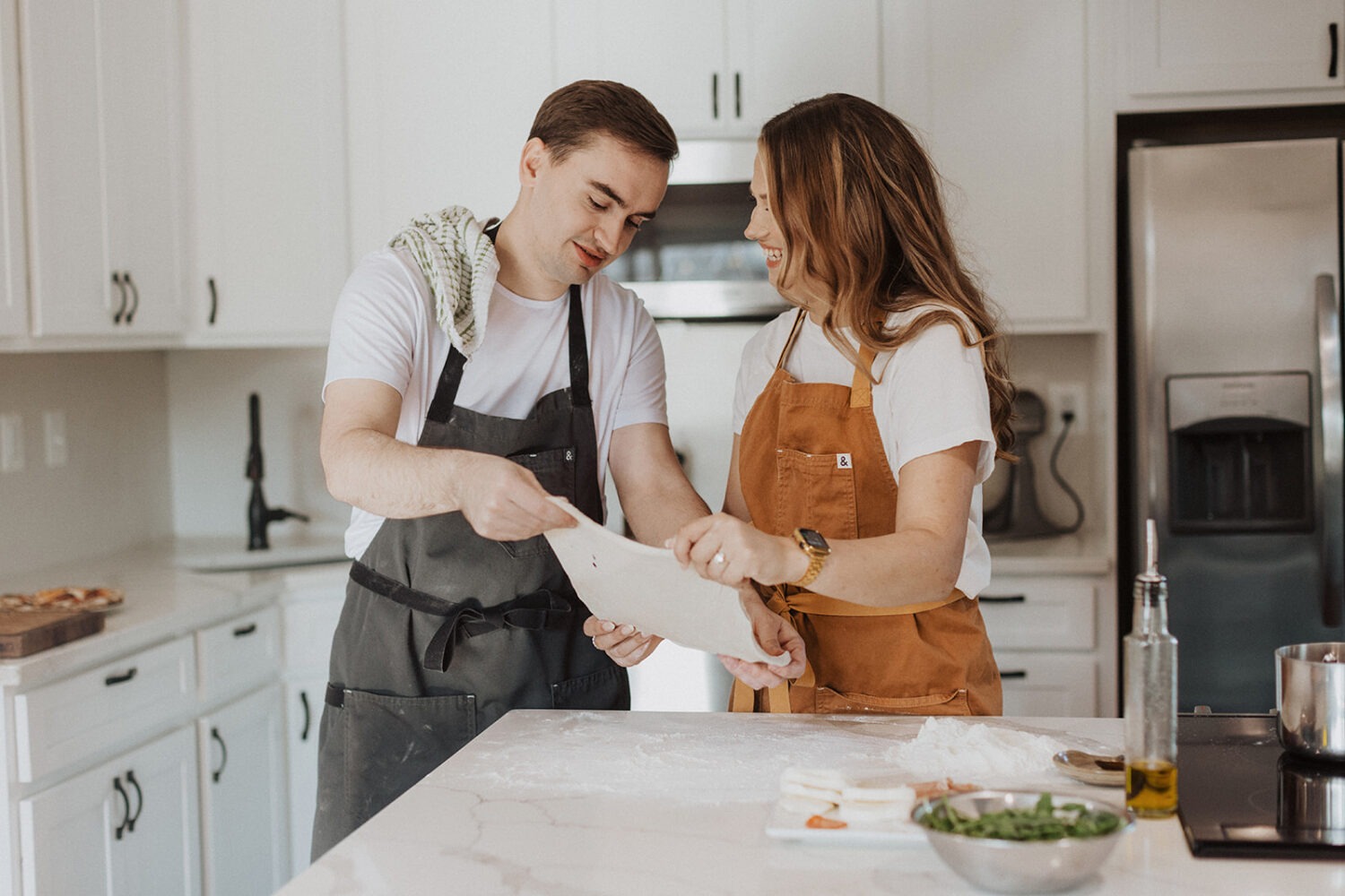 couple makes pizza at home engagement session