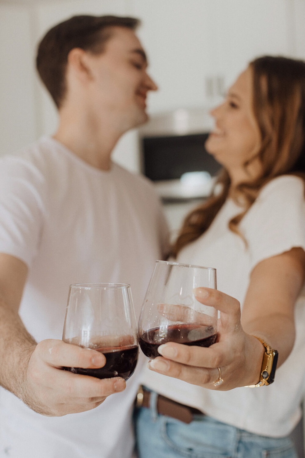 couple drinks wine together at home engagement session