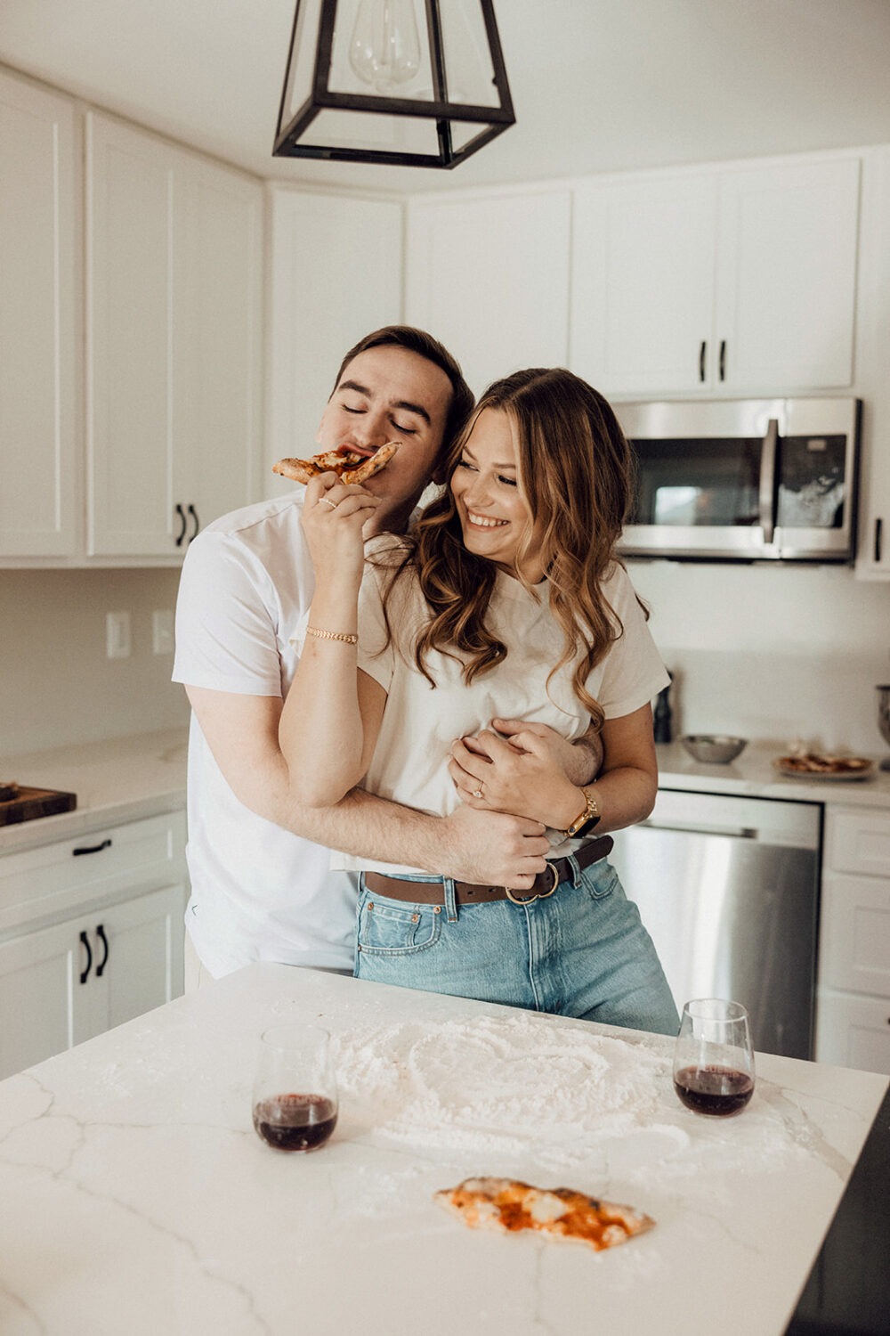 couple makes pizza together at home engagement session