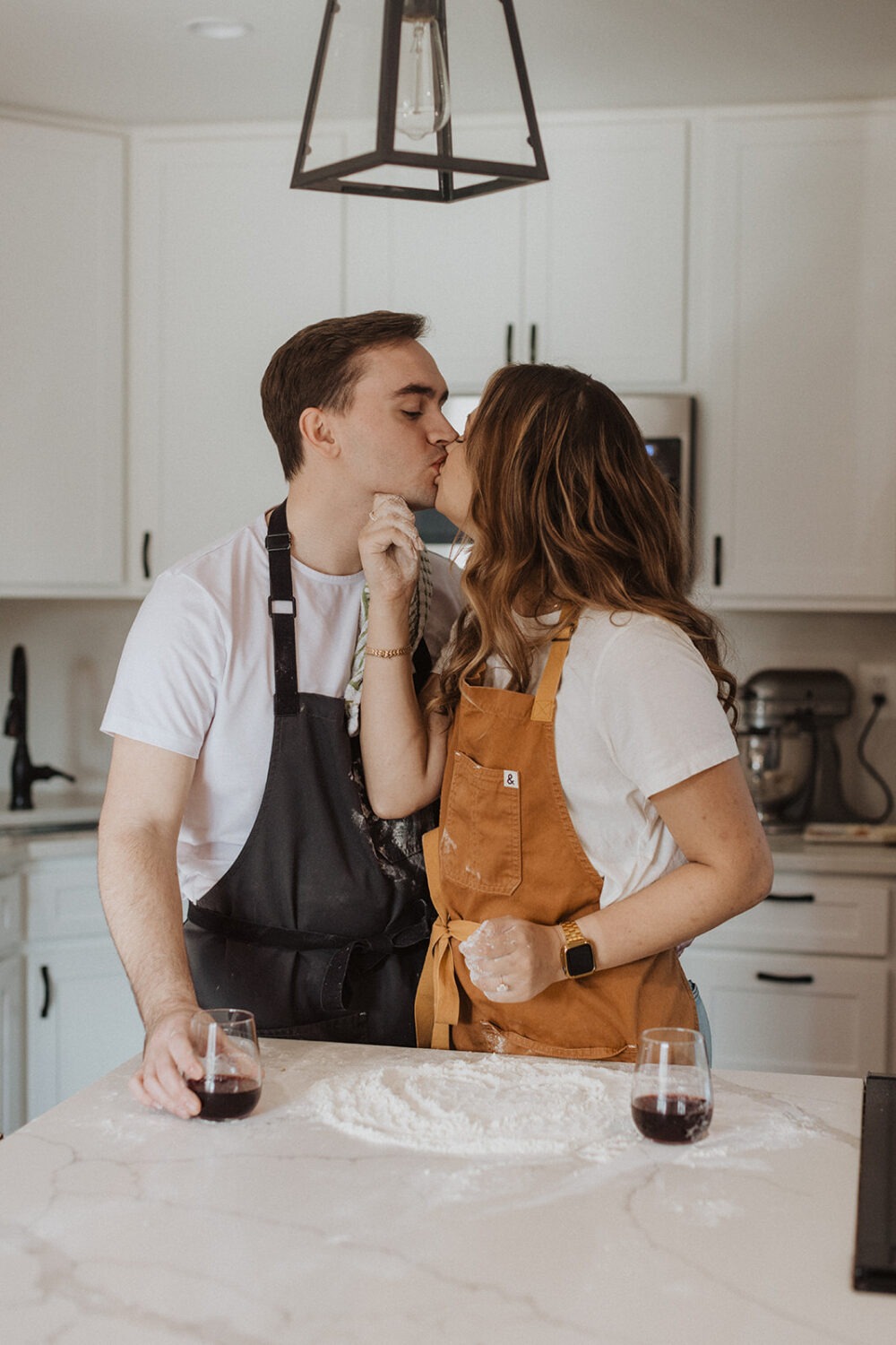 couple makes pizza together at home engagement session