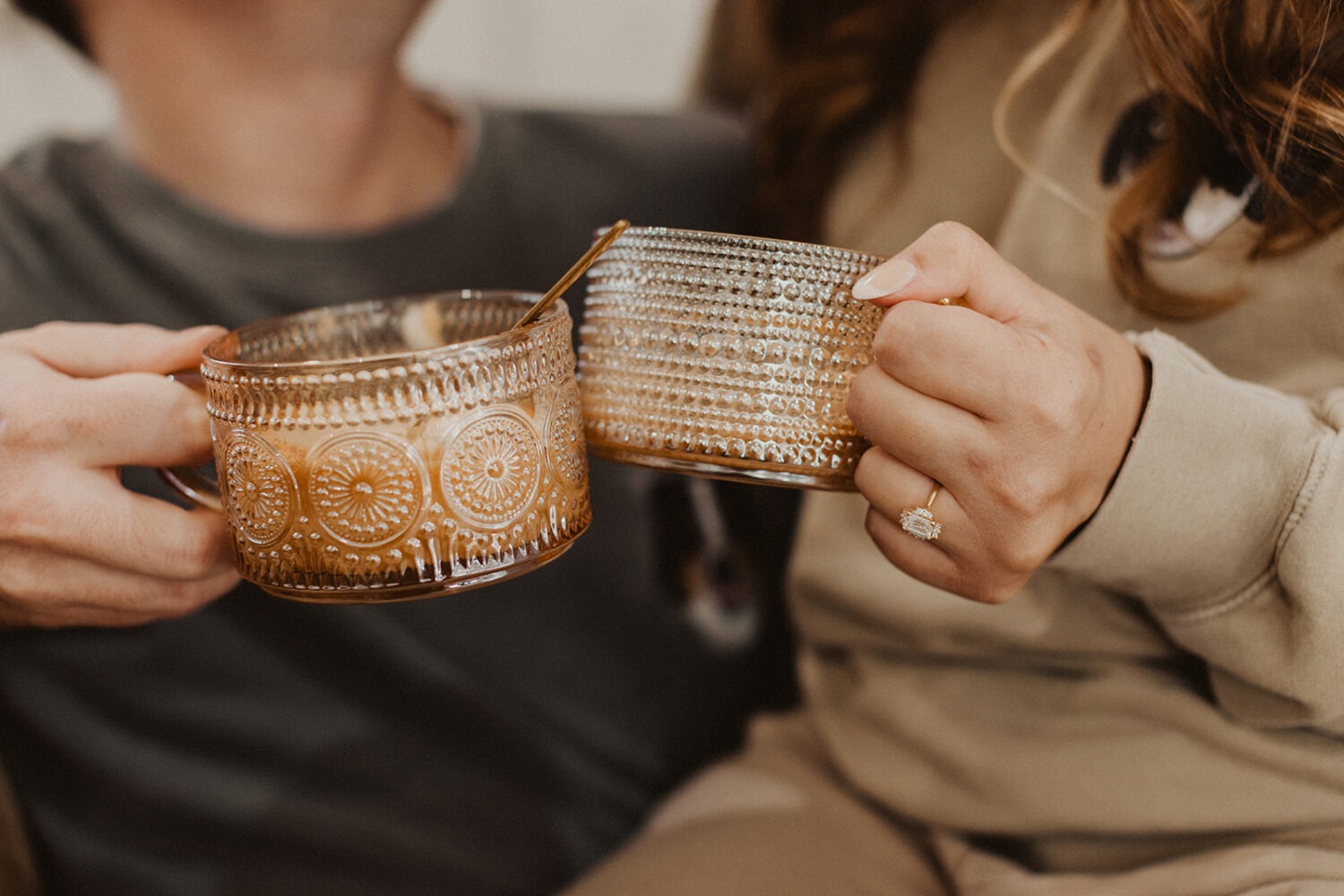 couple cheers with glasses at engagement session