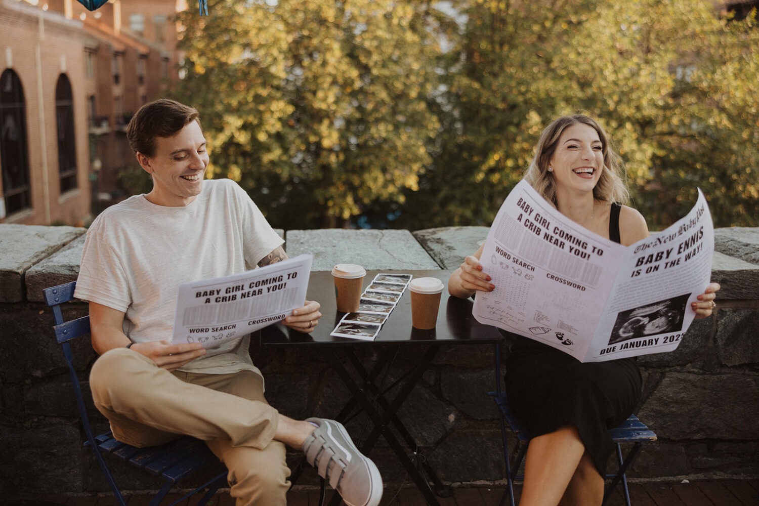 couple sits together with baby announcement newspaper 