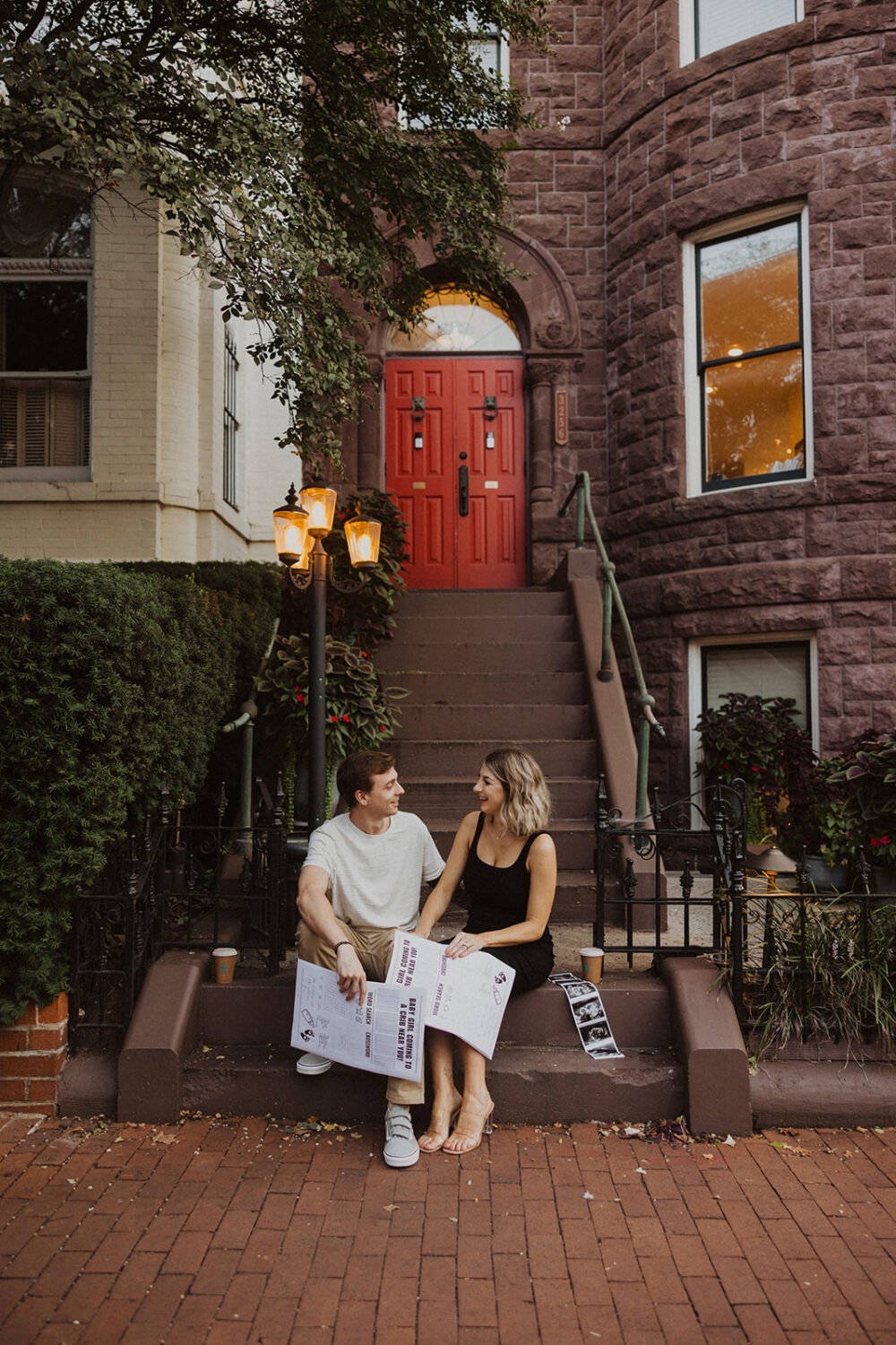 couple poses with their baby announcement newspaper while taking couples maternity photos