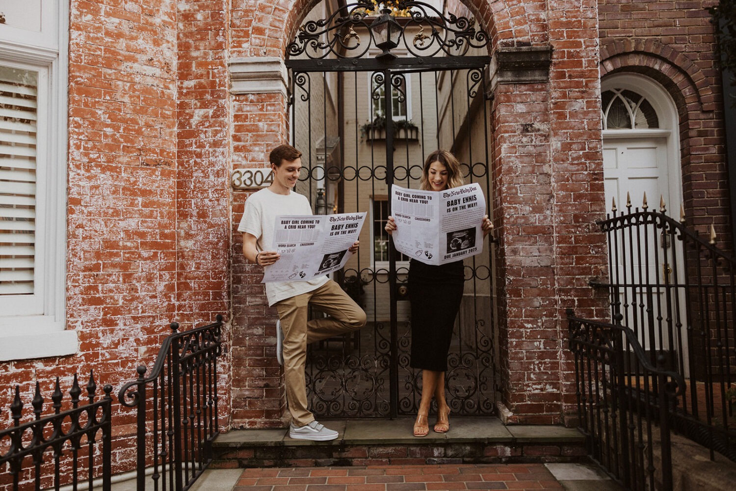 Couple reads through their baby announcement newspaper while taking couples maternity photos