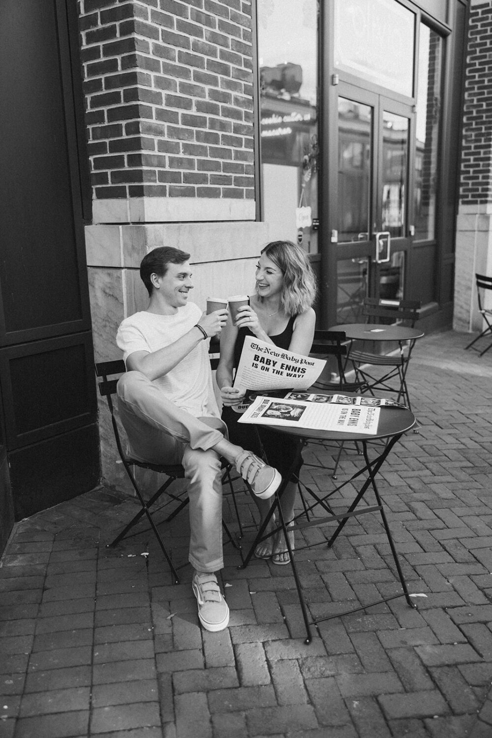 couple holds hands while enjoying coffee and their baby sonogram