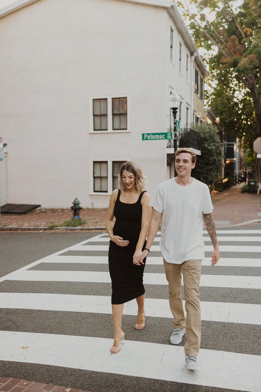 Couple walks though downtown Georgetown during their couples maternity photos