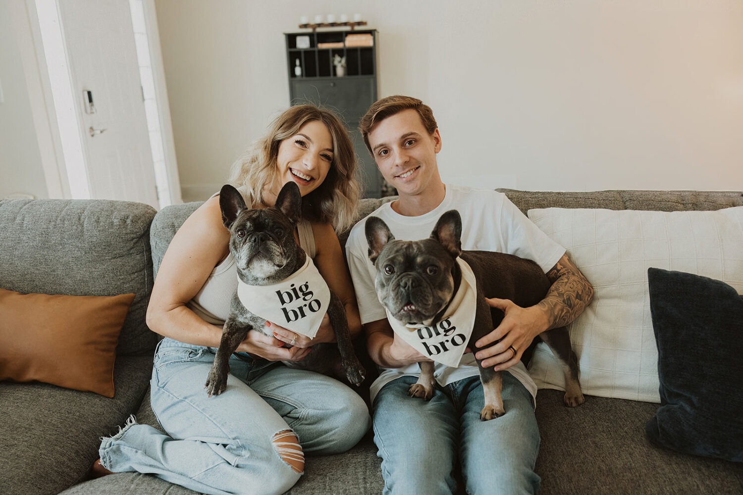 Couple holds their dogs in their home during couples maternity photos