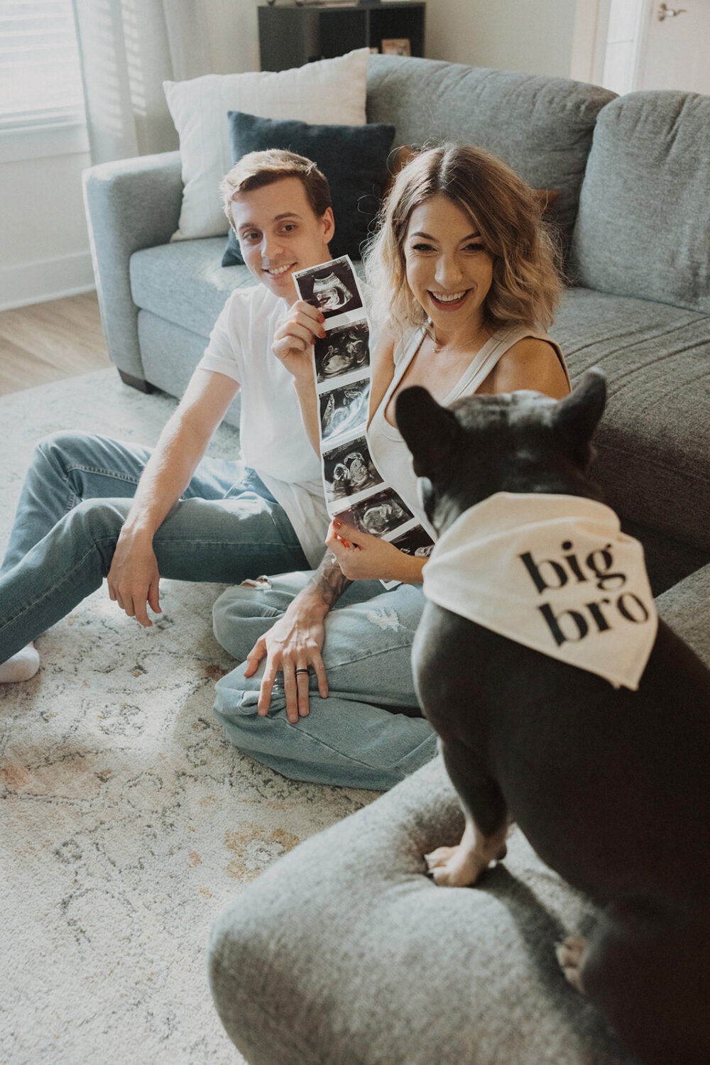 Couple holds sonogram at home with their dog