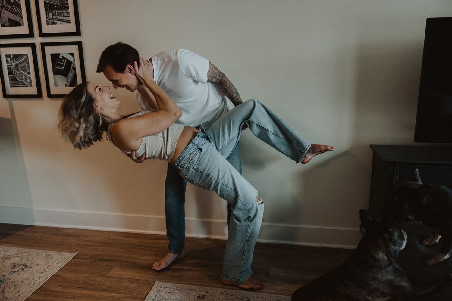 couple embraces in their home while taking couples maternity photos