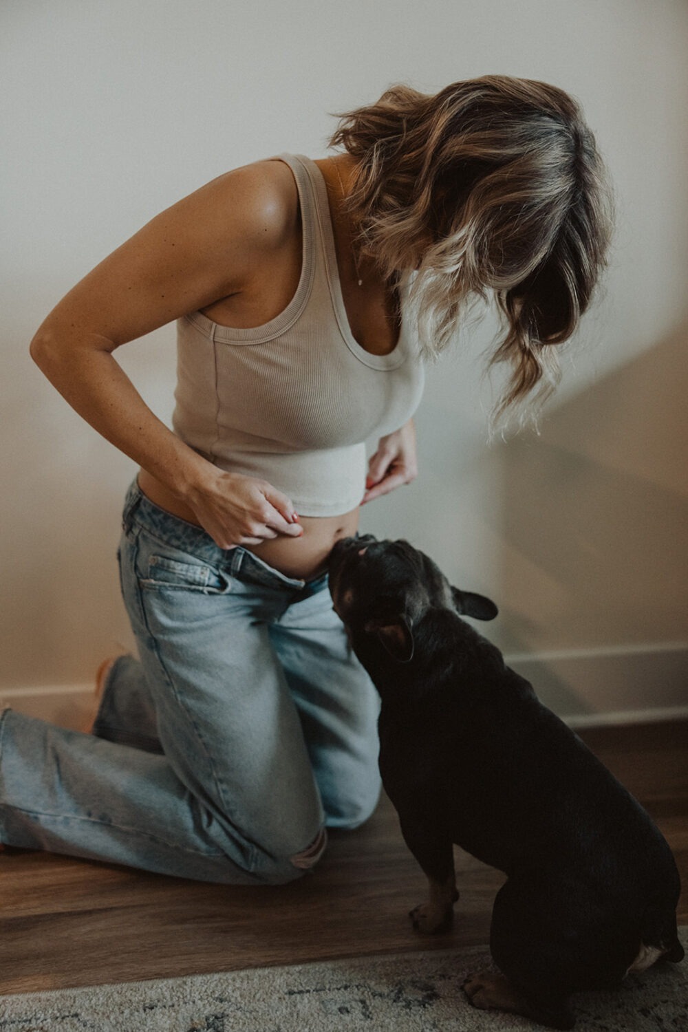 Woman poses with her baby bump and her dog