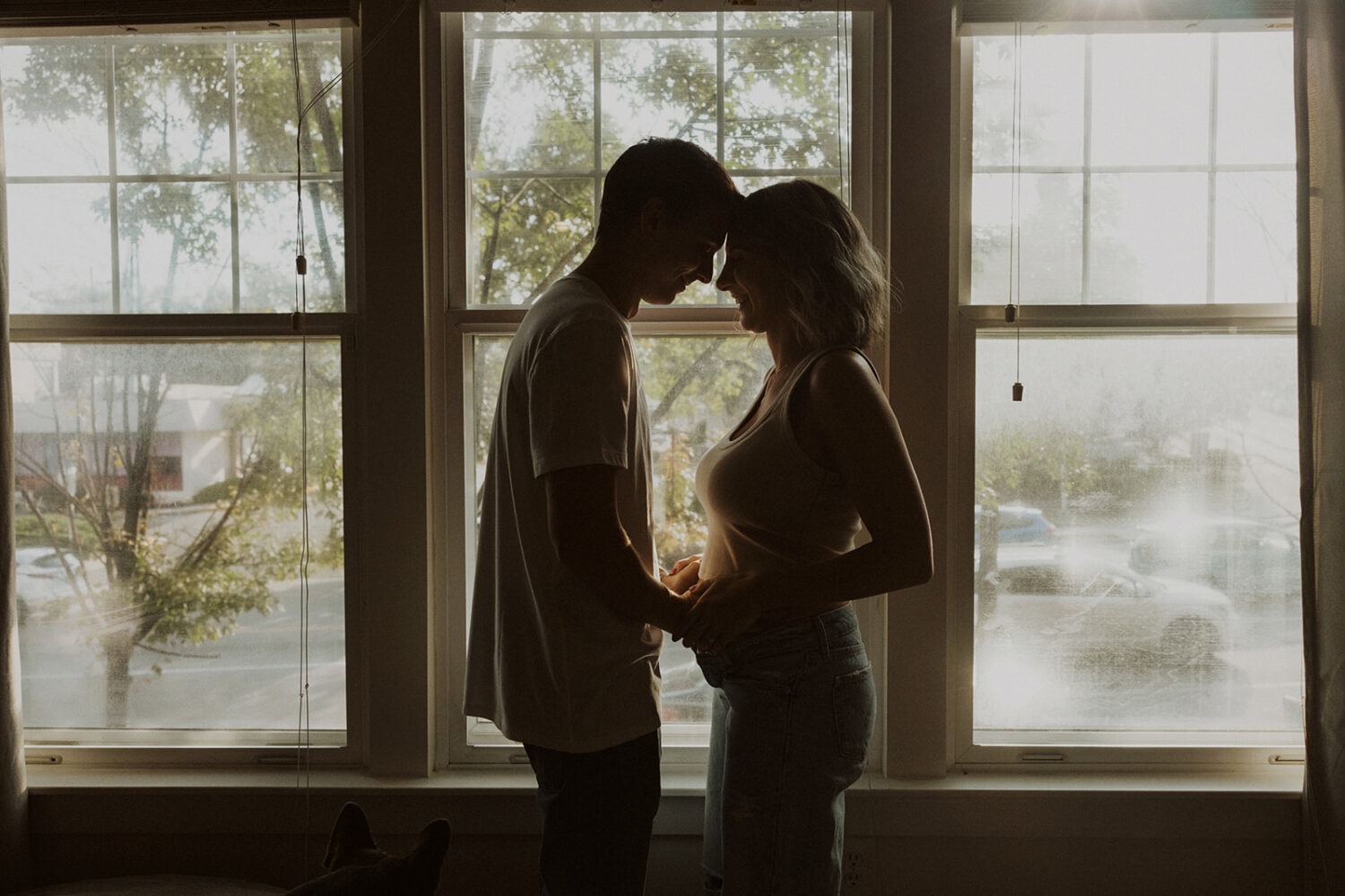 couple embraces during at-home maternity session