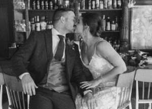 couple kisses at bar during wedding