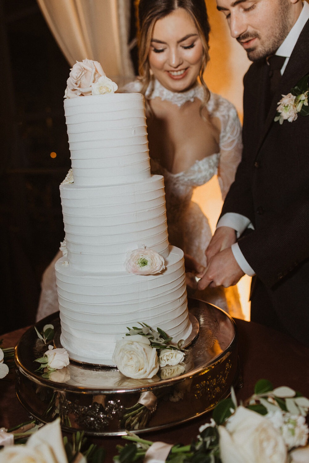 couple cuts white wedding cake