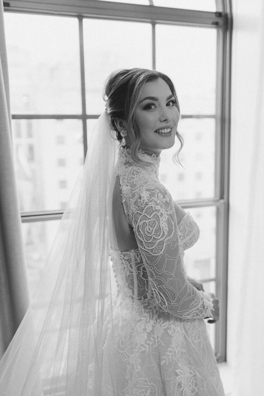 bride poses in front of window