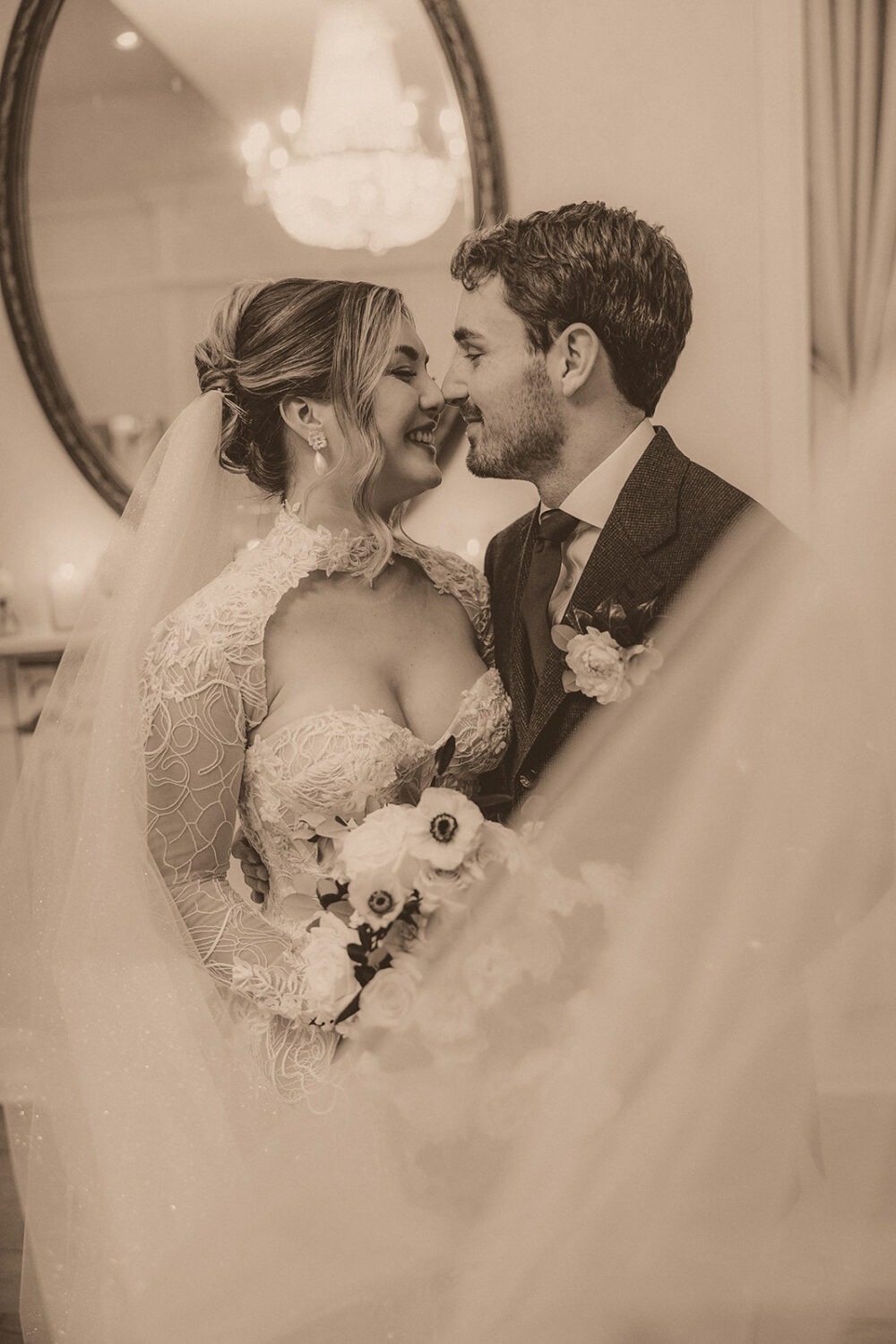 couple kisses under wedding veil