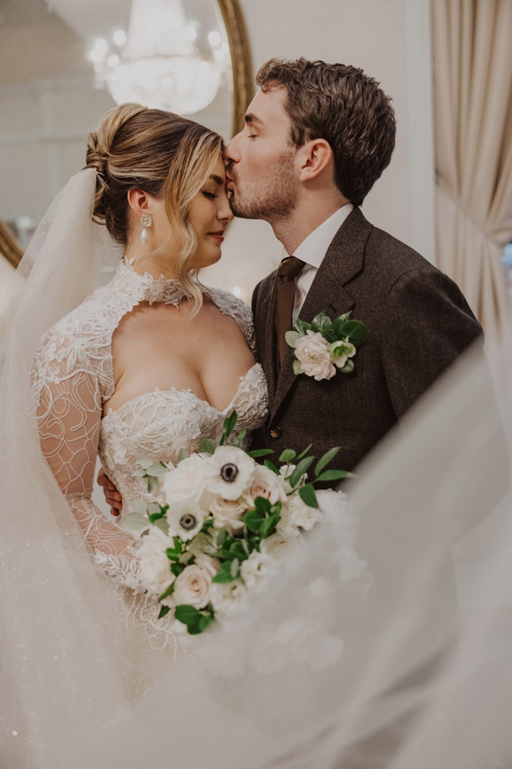 groom kisses bride's forehead 