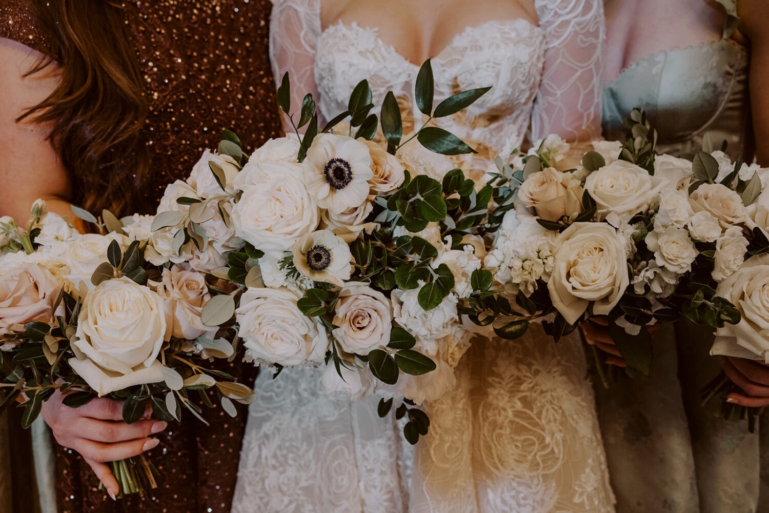 bride holds wedding bouquets with bridesmaids