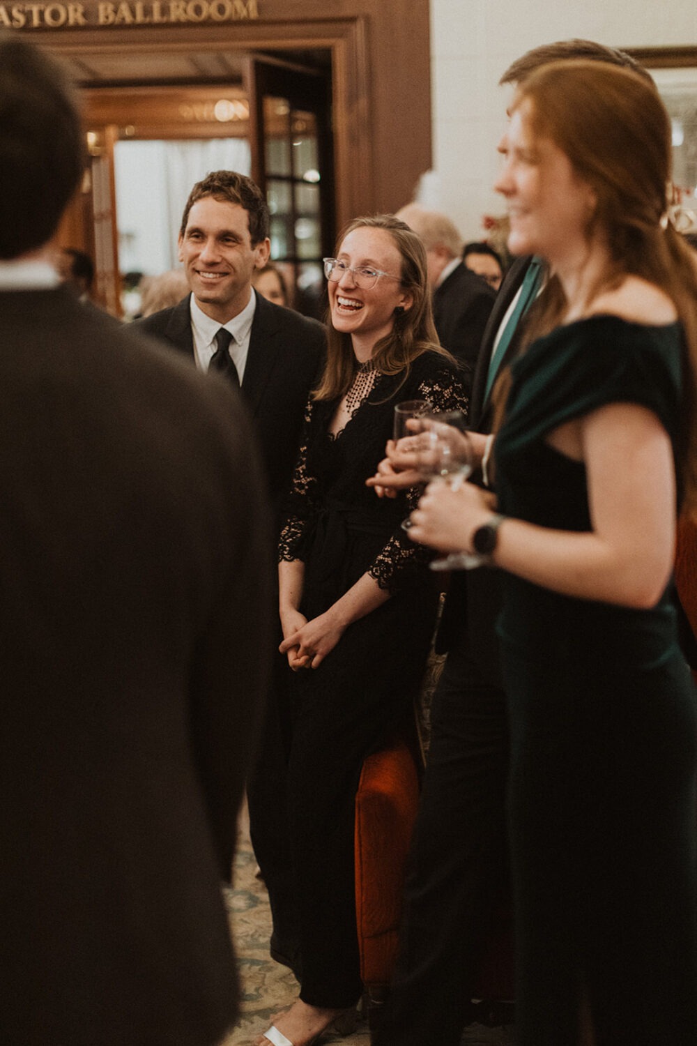 guests laugh during wedding cocktail hour