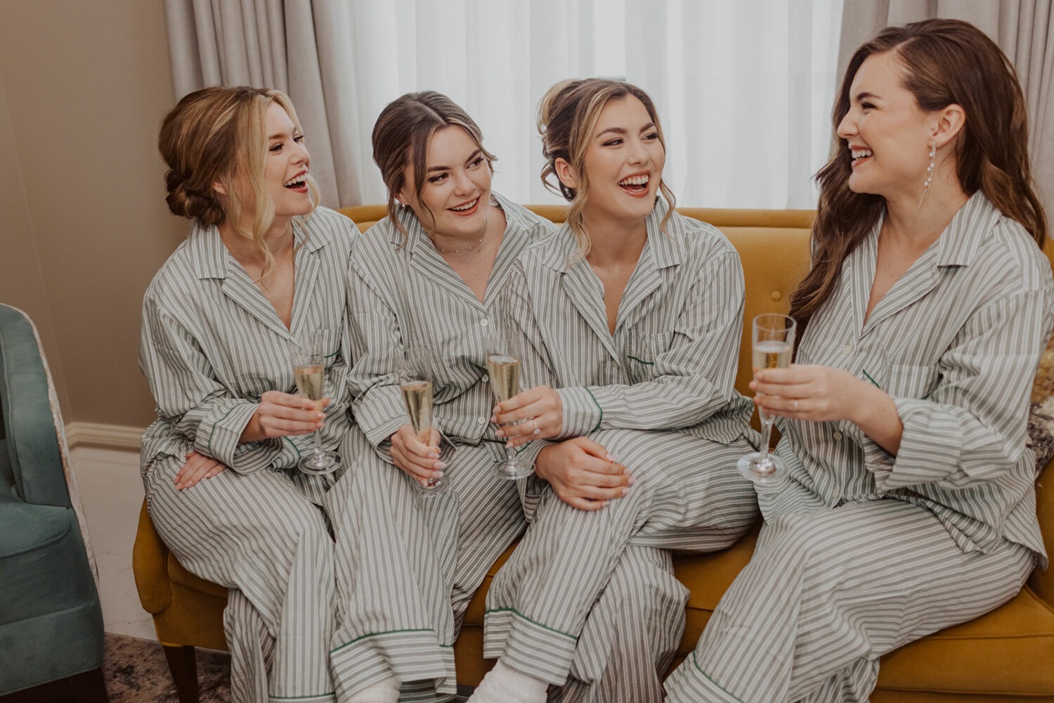 bride laughs with bridesmaids in matching pajamas