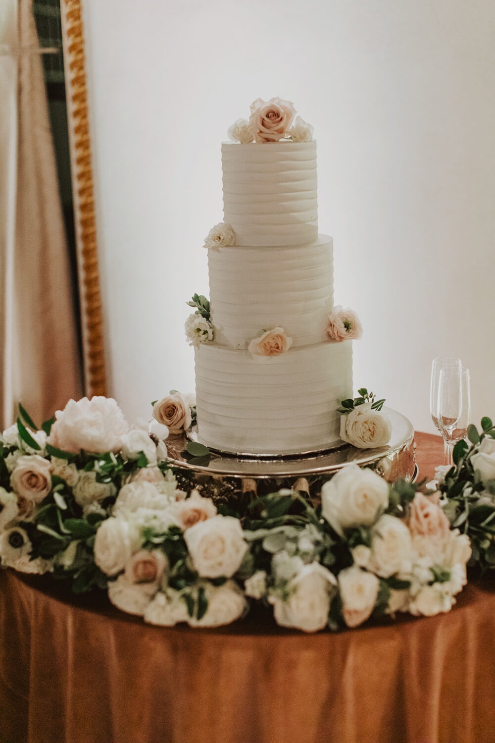 white wedding cake surrounded by florals at St. Regis DC hotel