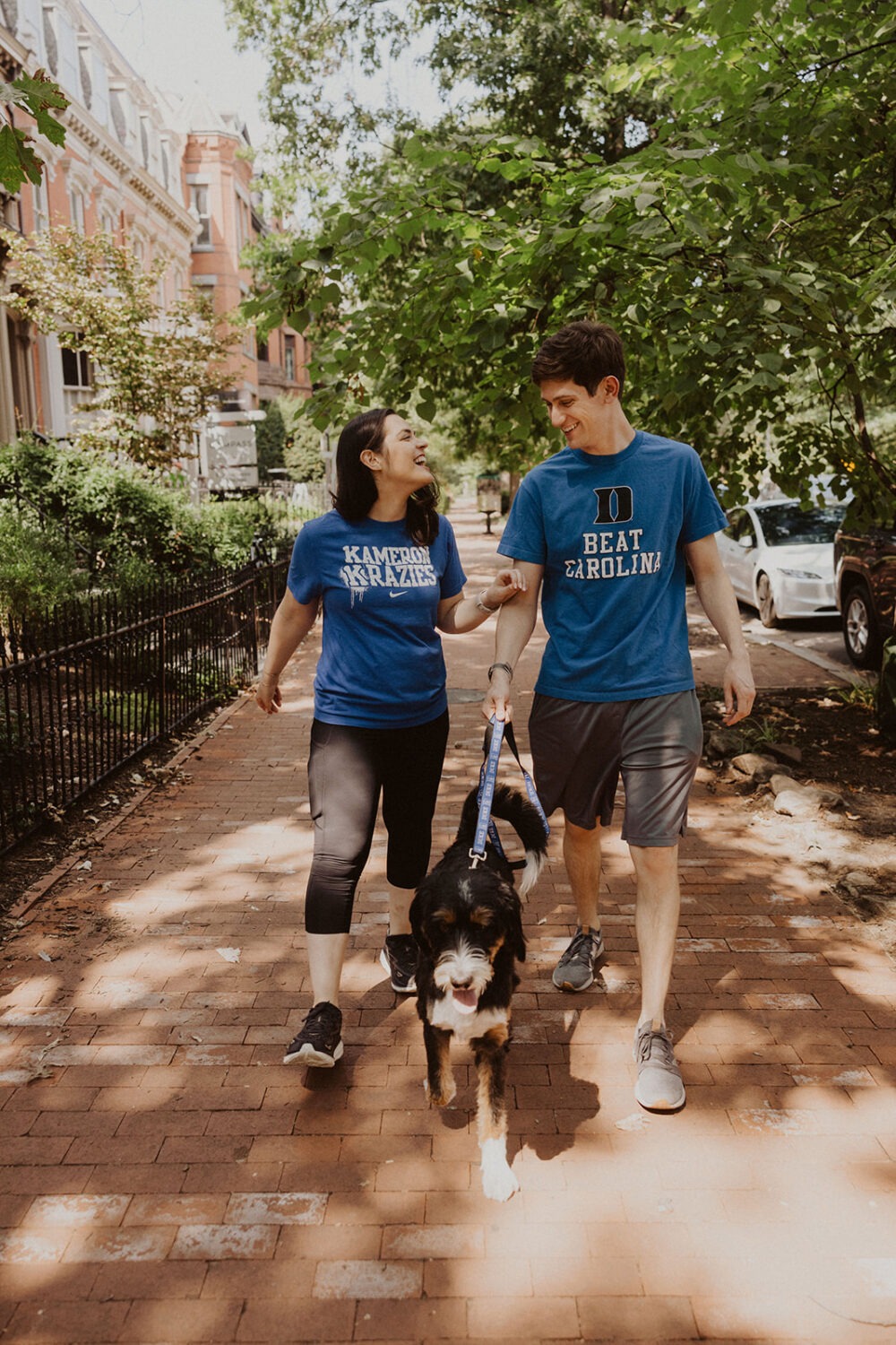 couple walks with dog during engagement shoot