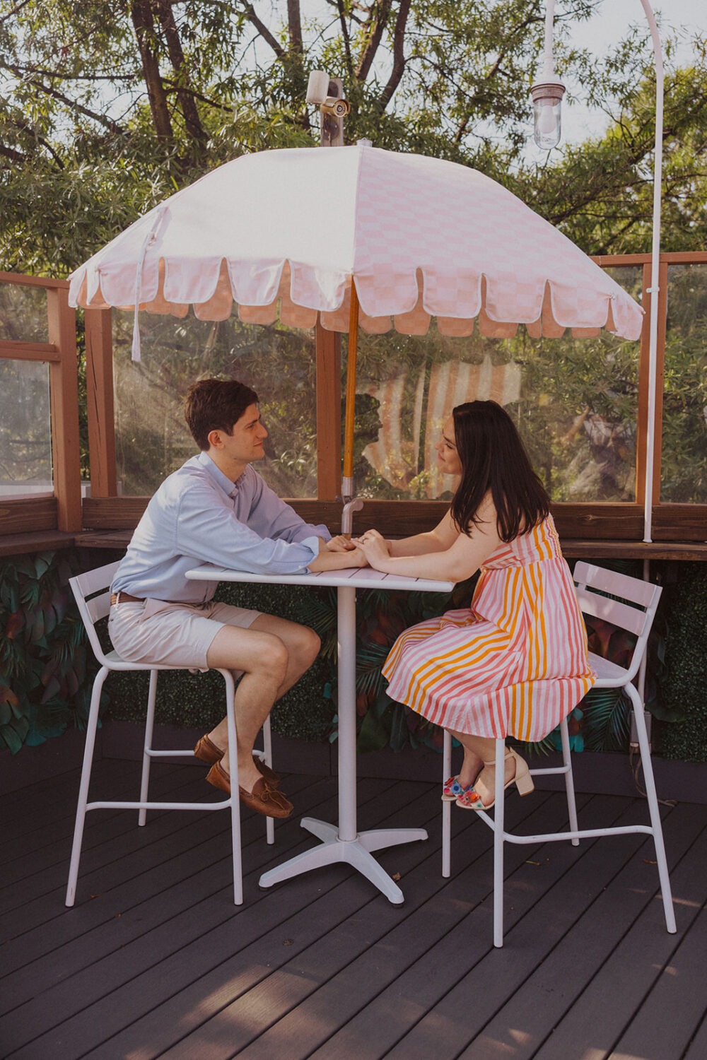 couple sitting holding hands during engagement shoot