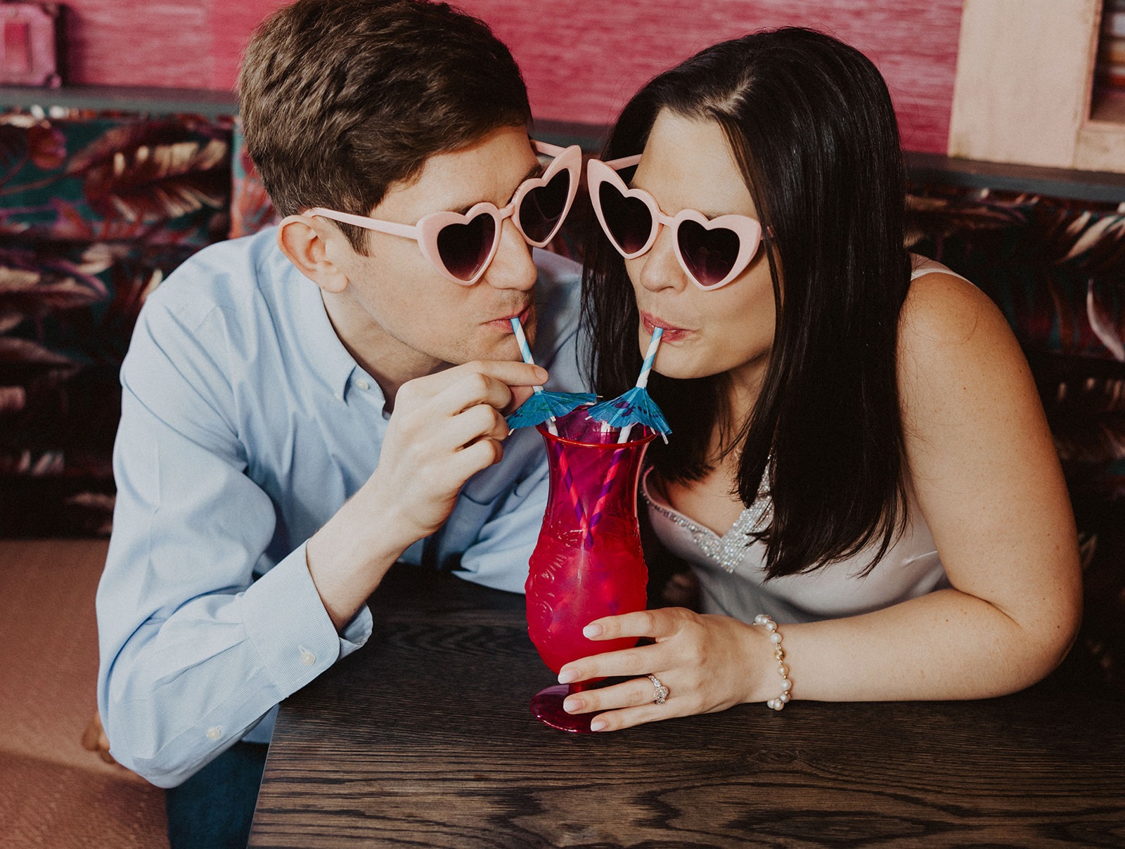 couple sips on cocktail at engagement session