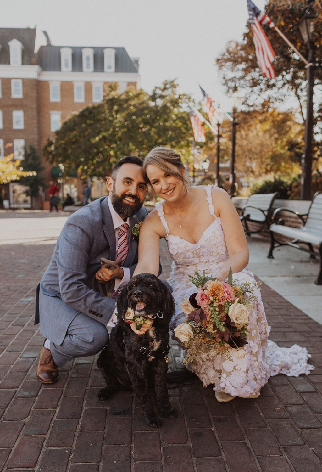 couple posing with their dog outside after ceremony
