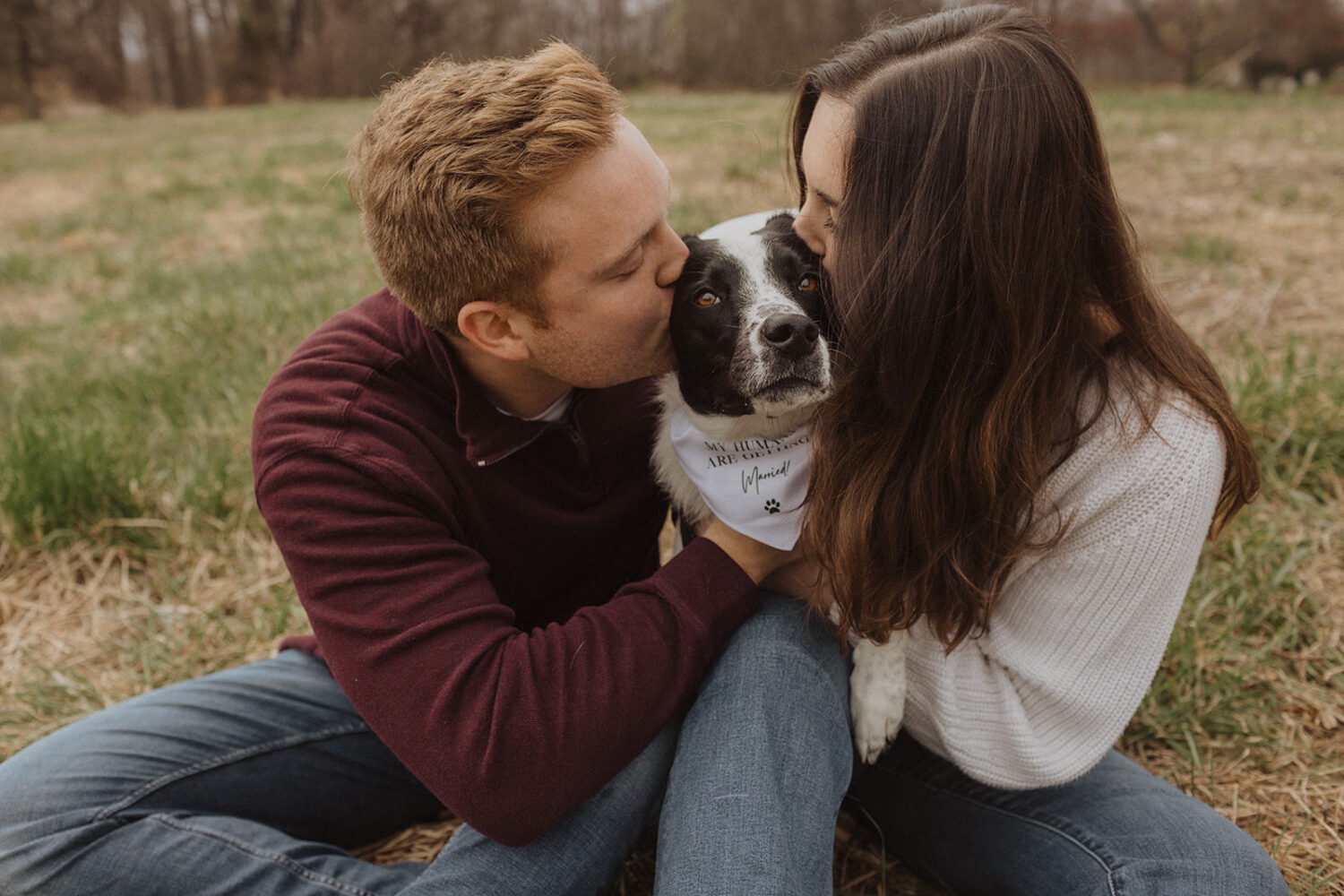 couple kissing their dog during engagement session 